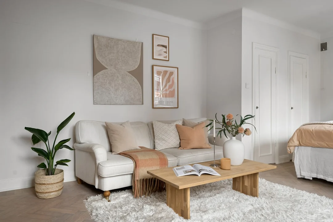 A living room filled with furniture and a white rug. related to Neutral Room Decor Is a Layered System of Warm, Cool & Earth Tones