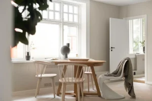 A room with a table, chairs and a potted plant. related to Warm Scandinavian Decor: How to Make Minimalist Nordic Interiors Feel Lived-In (Not Sterile)
