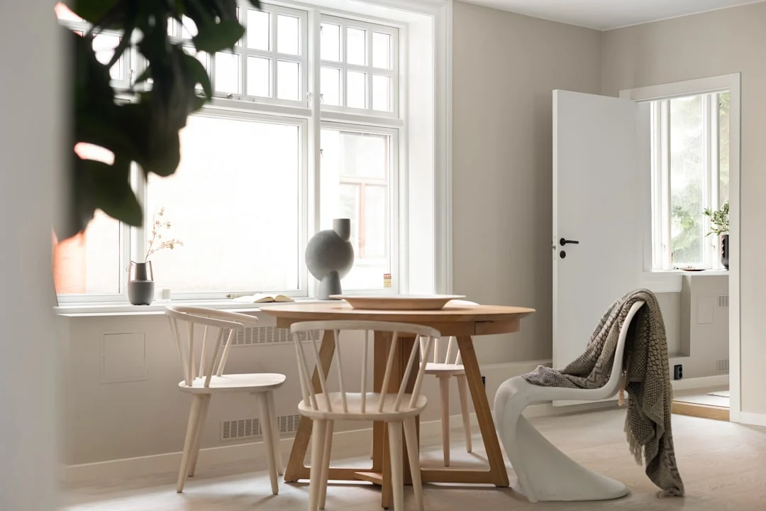 A room with a table, chairs and a potted plant. related to Warm Scandinavian Decor: How to Make Minimalist Nordic Interiors Feel Lived-In (Not Sterile)