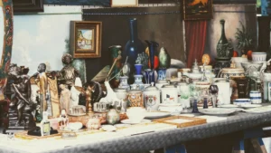a table topped with lots of different types of vases. related to Authentic Vintage vs. Reproduction: How to Spot Real Vintage Accessories and Build a Cohesive Collection