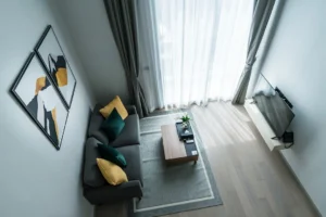 Modern living room with gray sofa and abstract art.. related to How to Decorate a Small Apartment Living Room (Without Overcrowding It)