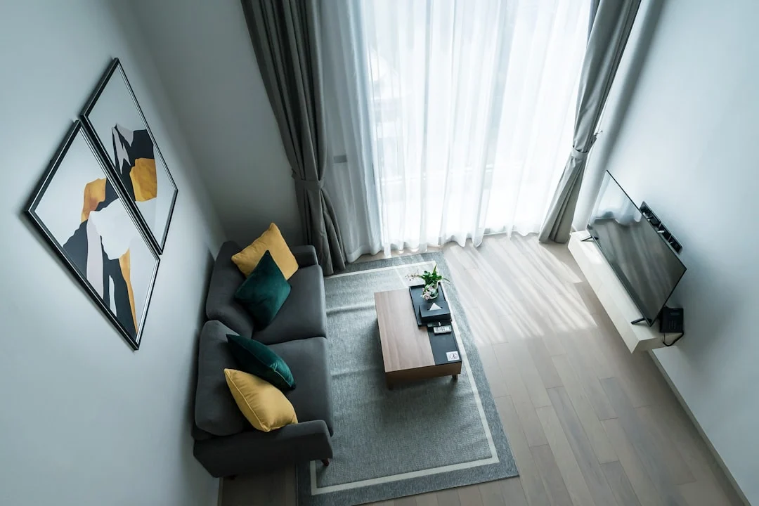 Modern living room with gray sofa and abstract art.. related to How to Decorate a Small Apartment Living Room (Without Overcrowding It)