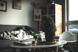 oval white wooden coffee table near vacant sofa. related to Small Changes, Big Impact: How Intentional Layering Creates a Cozy Living Room on a Budget