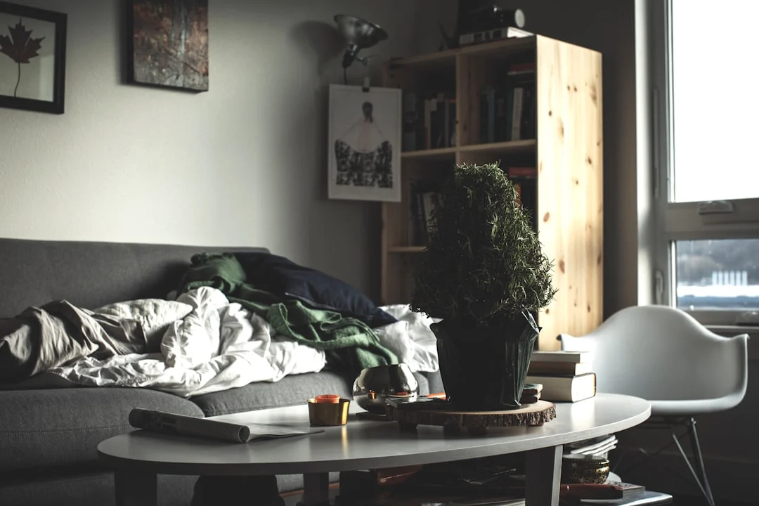 oval white wooden coffee table near vacant sofa. related to Small Changes, Big Impact: How Intentional Layering Creates a Cozy Living Room on a Budget